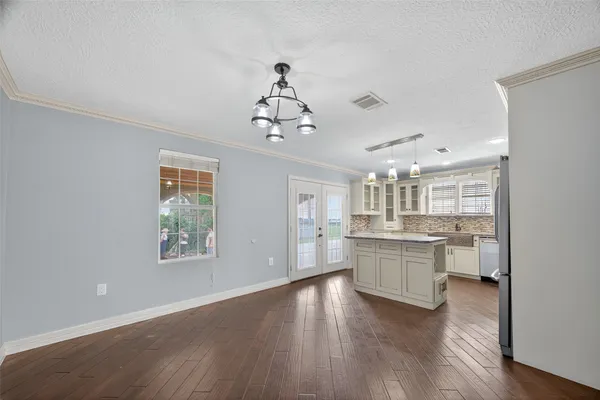 a kitchen with kitchen island wooden floors and stainless steel appliances
