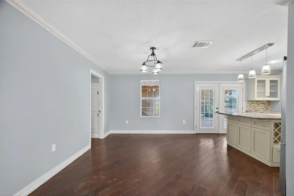a view of an empty room with window and wooden floor