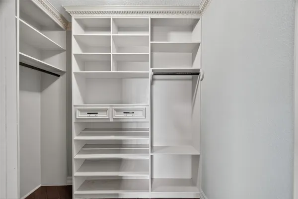 a view of walk in closet with empty racks