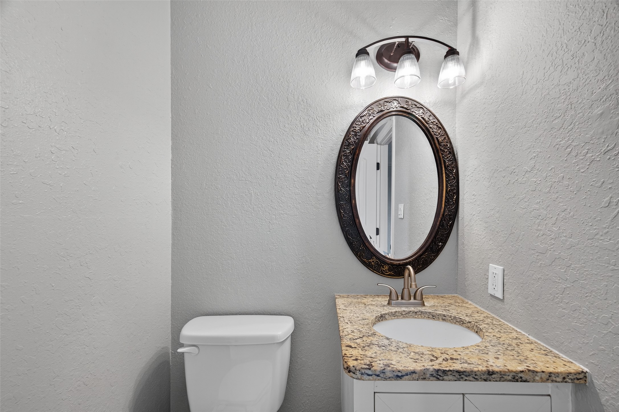 16809 Market Street Channelview, TX 77530 - Photo 31 of 35 a bathroom with a granite countertop toilet a sink and a mirror