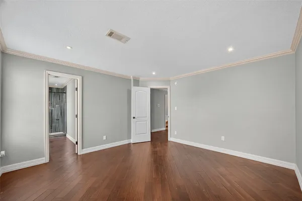 a view of an empty room with wooden floor