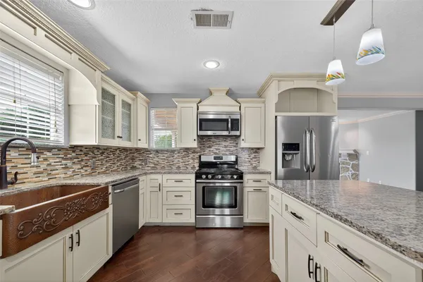 a kitchen with stainless steel appliances granite countertop a stove and a sink