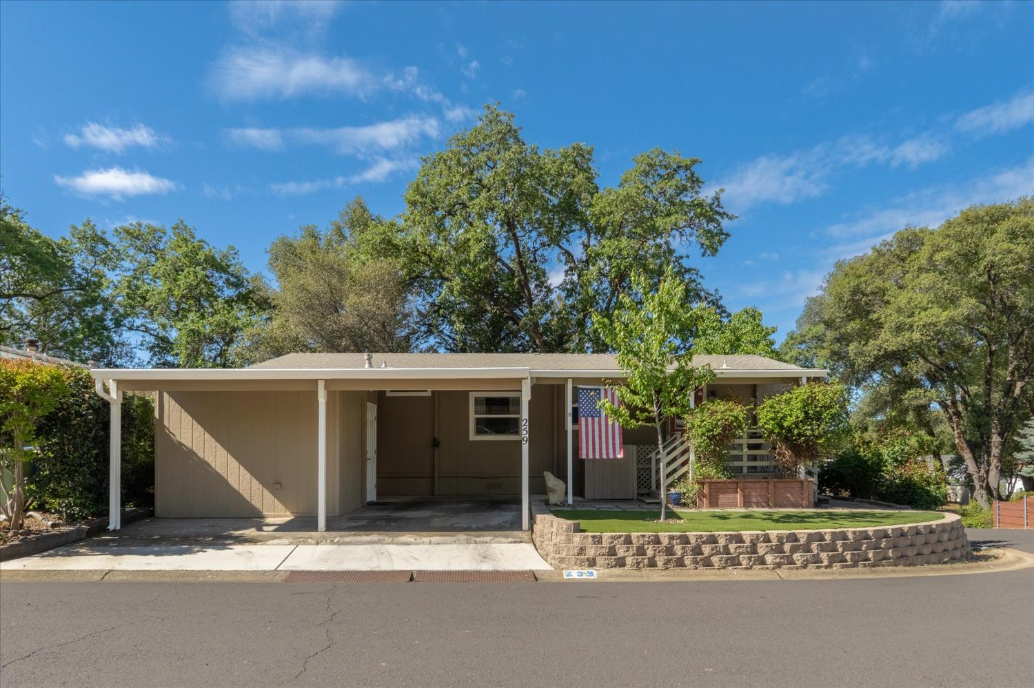 340 Tom Bell Road, Unit 259 Murphys, CA 95247 - Photo 2 of 43 Property features a covered carport, shed with shelving and electricity for storage (or workshop), covered front porch, low maintenance artificial grass and stacked stone retaining walls.