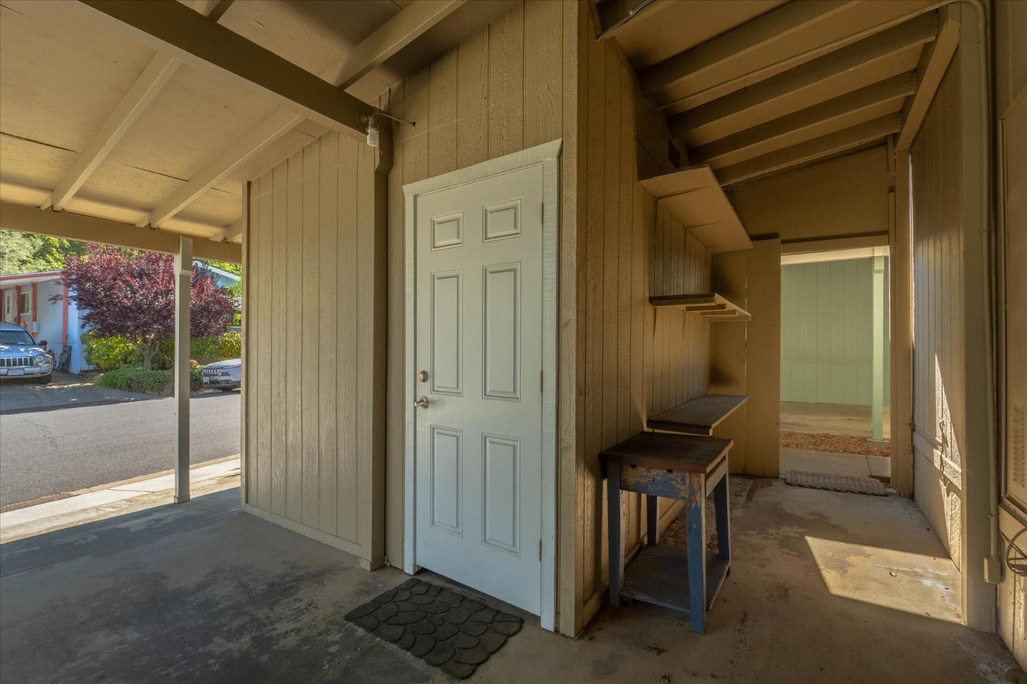 340 Tom Bell Road, Unit 259 Murphys, CA 95247 - Photo 26 of 43 Door to shed, plus additional exterior storage shelving and workbench with a view to back pathway to backyard.