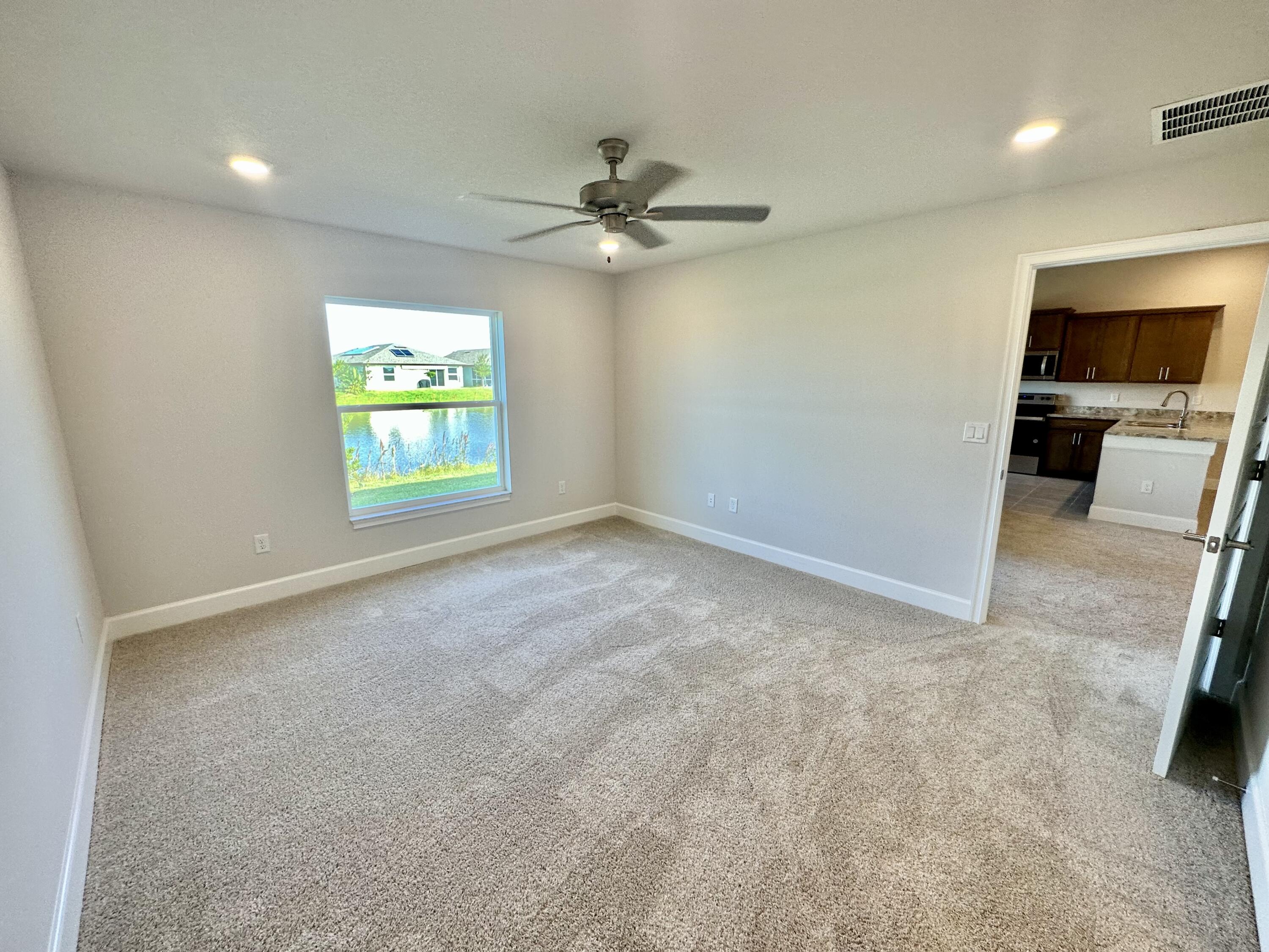 8634 Modeno Street Fort Pierce, FL 34951 - Photo 14 of 34 an empty room with windows and ceiling fan