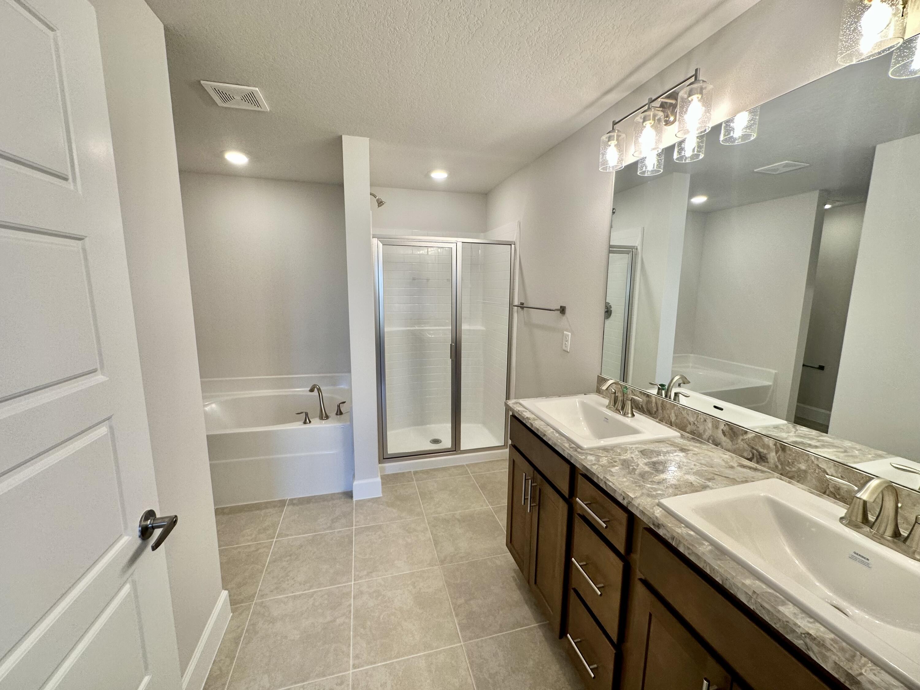 8634 Modeno Street Fort Pierce, FL 34951 - Photo 15 of 34 a bathroom with a granite countertop sink a toilet a mirror and shower