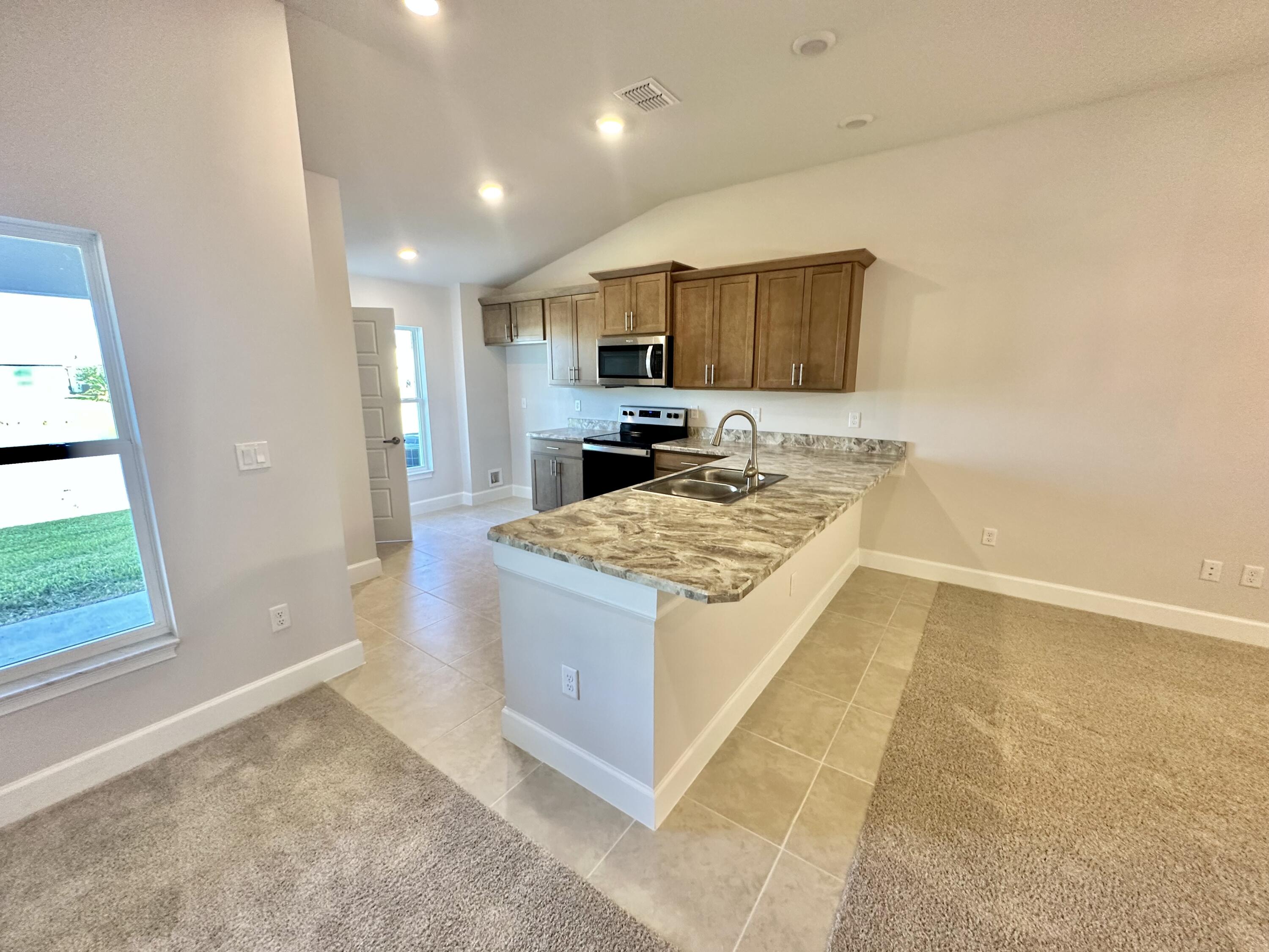 8634 Modeno Street Fort Pierce, FL 34951 - Photo 3 of 34 a kitchen with a stove and a sink