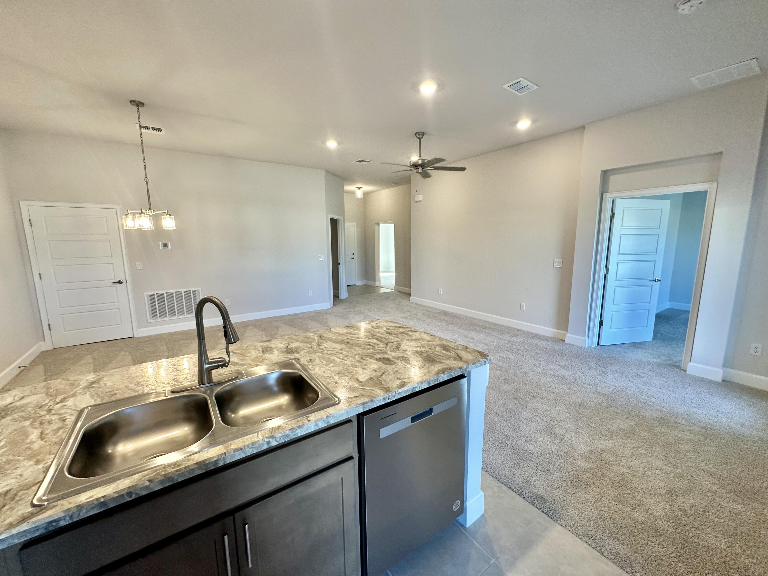 8634 Modeno Street Fort Pierce, FL 34951 - Photo 4 of 34 a kitchen with granite countertop a sink and a wooden floor