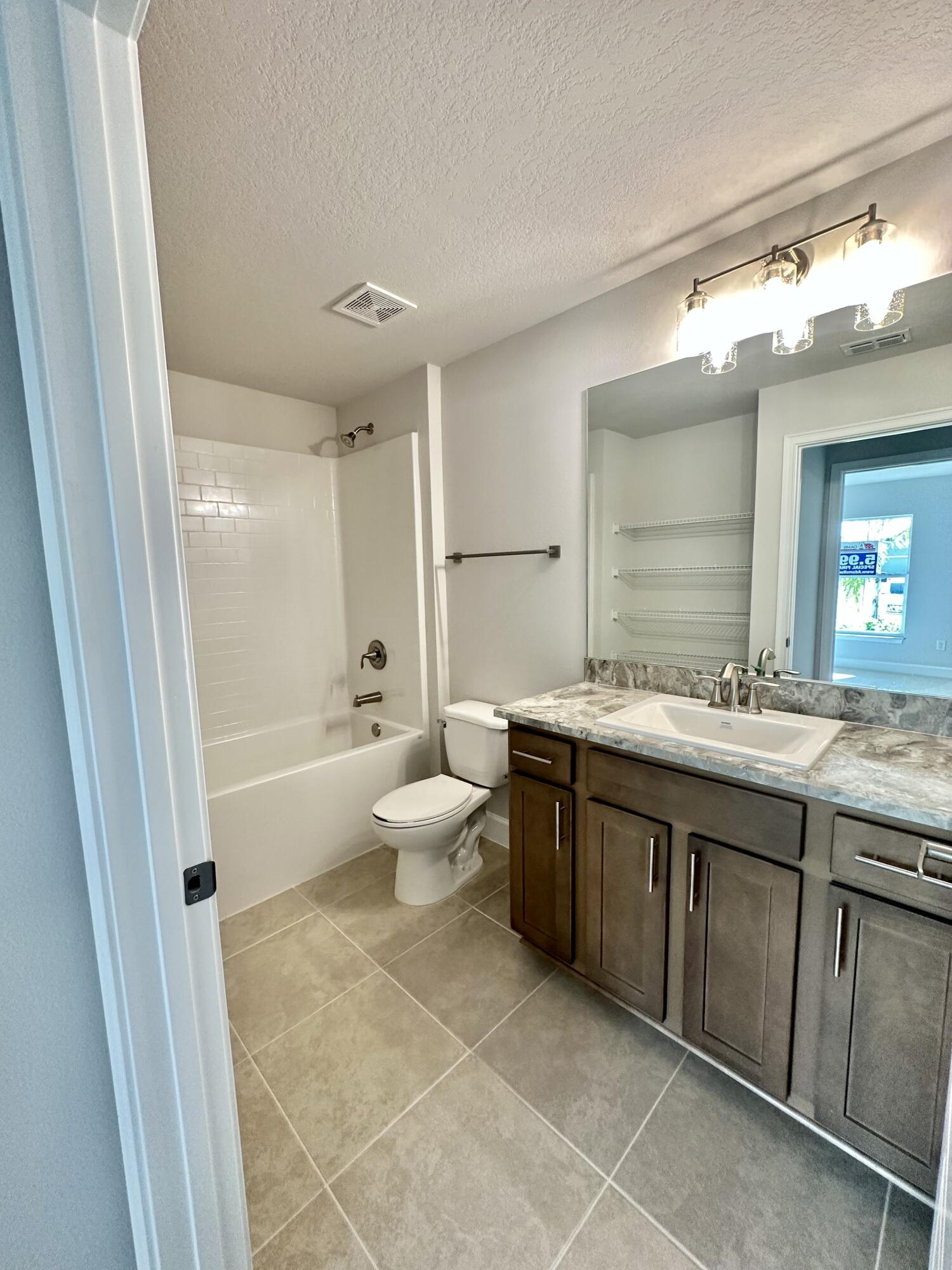 8634 Modeno Street Fort Pierce, FL 34951 - Photo 7 of 34 a spacious bathroom with a granite countertop sink toilet mirror and bathtub