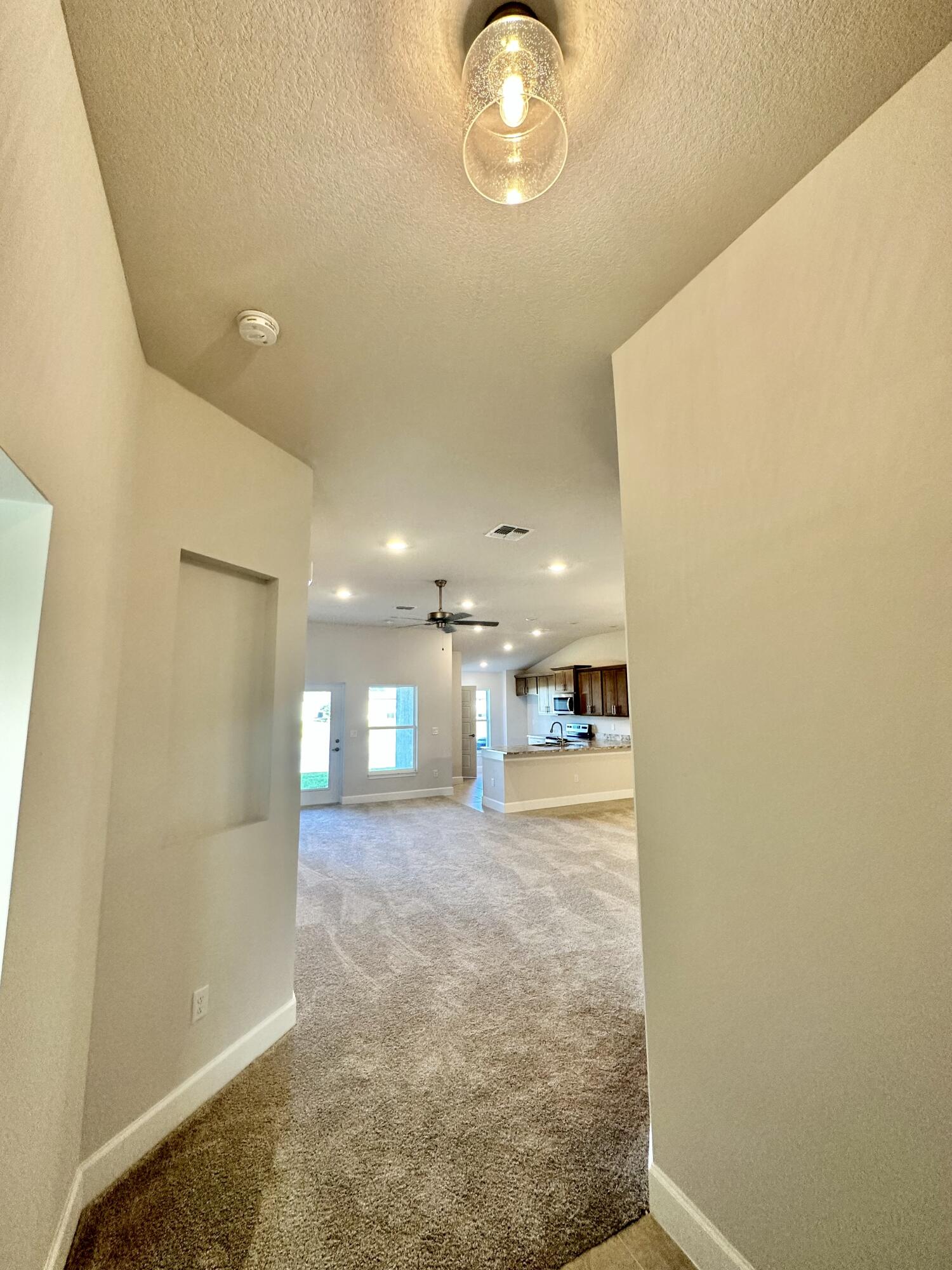 8634 Modeno Street Fort Pierce, FL 34951 - Photo 10 of 34 a view of a hallway with a chandelier