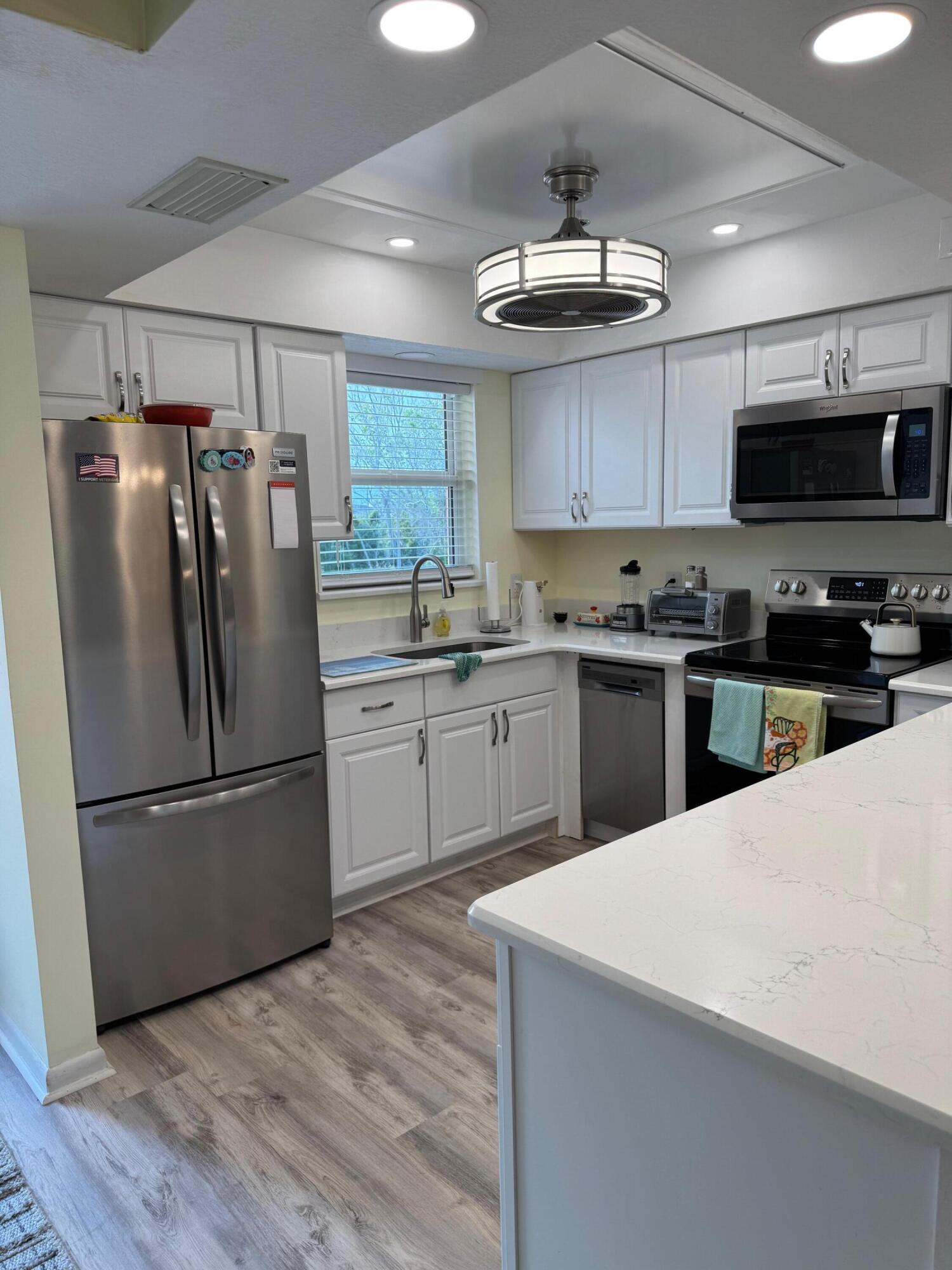 a kitchen with stainless steel appliances a refrigerator sink and microwave