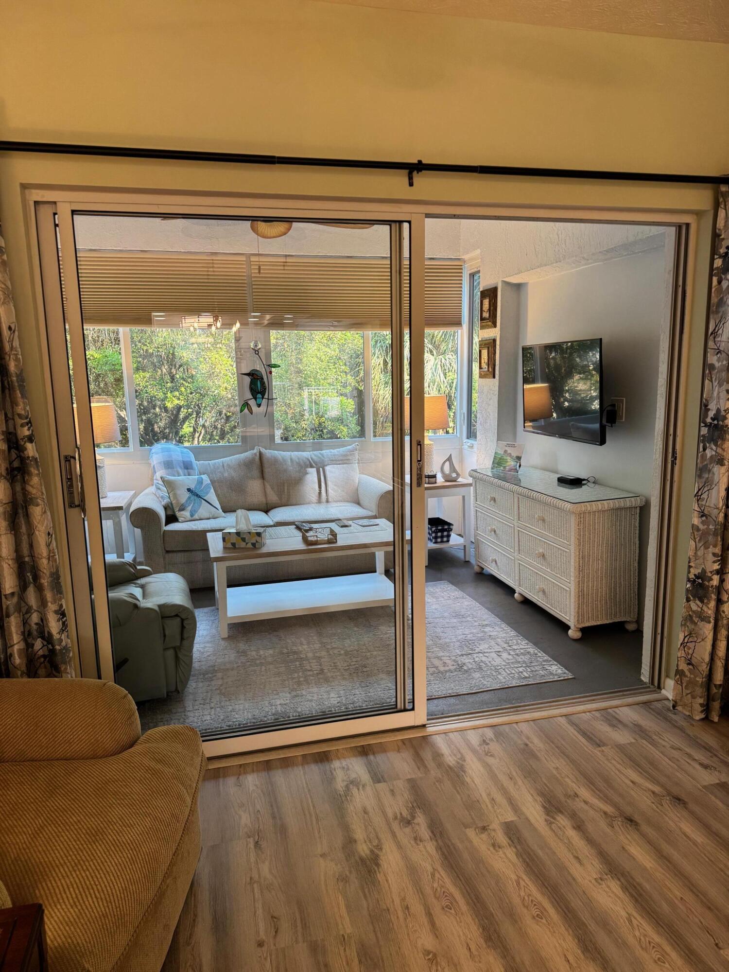 2950 Southeast Ocean Boulevard, Unit 110202 Stuart, FL 34996 - Photo 11 of 25 a living room with furniture and a flat screen tv