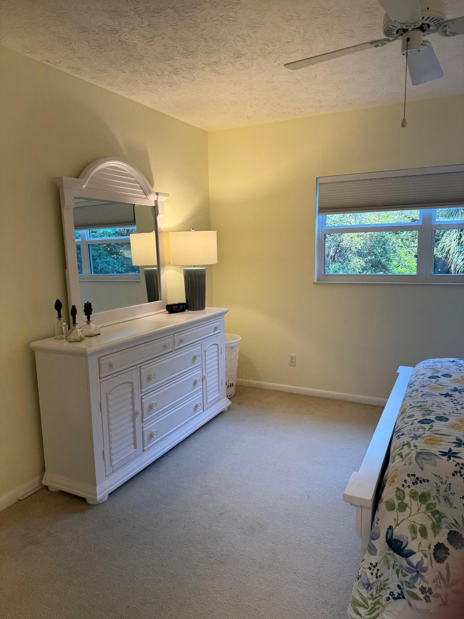 2950 Southeast Ocean Boulevard, Unit 110202 Stuart, FL 34996 - Photo 13 of 25 a bedroom with a bed and a dresser