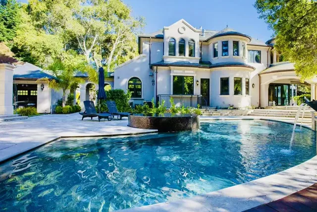 a front view of a house with garden and sitting area