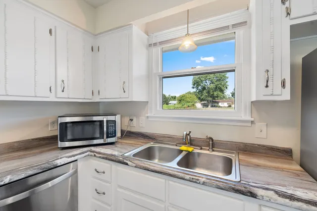 a kitchen with stainless steel appliances granite countertop a sink and a microwave
