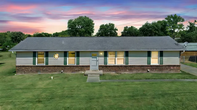 a view of house with a yard