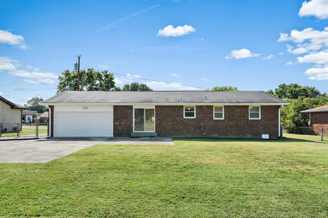 a view of a house with a yard and garage