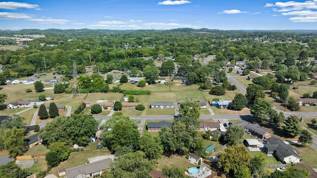 an aerial view of residential houses with outdoor space and trees