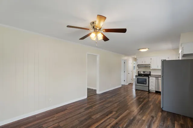 a view of kitchen with wooden floor a ceiling fan and stainless steel appliances