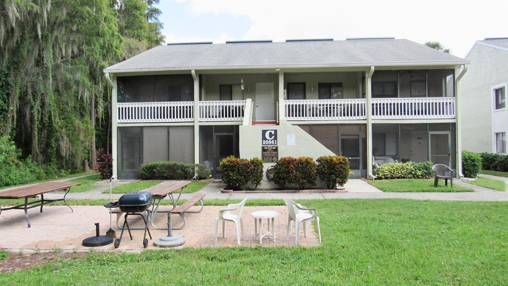 20861 Haulover Cove Road, Unit C4 Lutz, FL 33558 - Photo 14 of 22 a front view of a house with a yard table and chairs