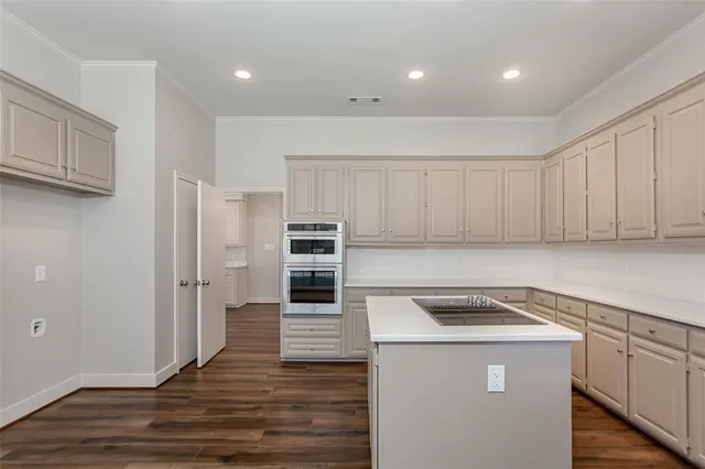 a kitchen with cabinets and steel appliances