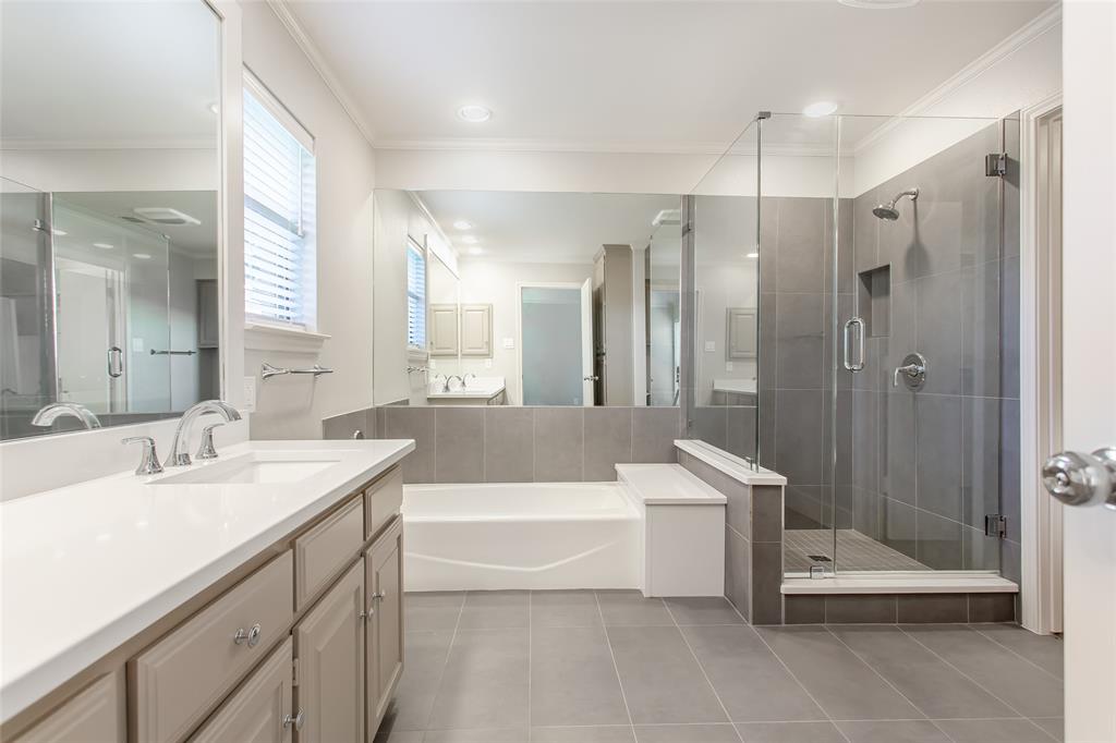 2117 Promontory Point Plano, TX 75075 - Photo 26 of 37 a bathroom with a tub a sink shower and mirror