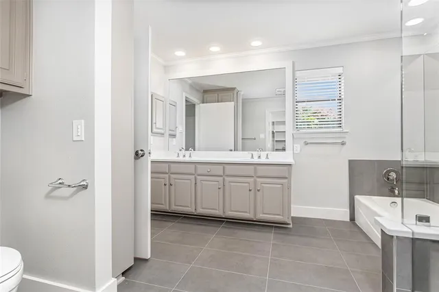 a large bathroom with a double vanity sink a mirror and a bathtub