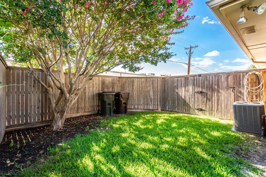 2117 Promontory Point Plano, TX 75075 - Photo 34 of 37 a view of a backyard with wooden fence and a large tree