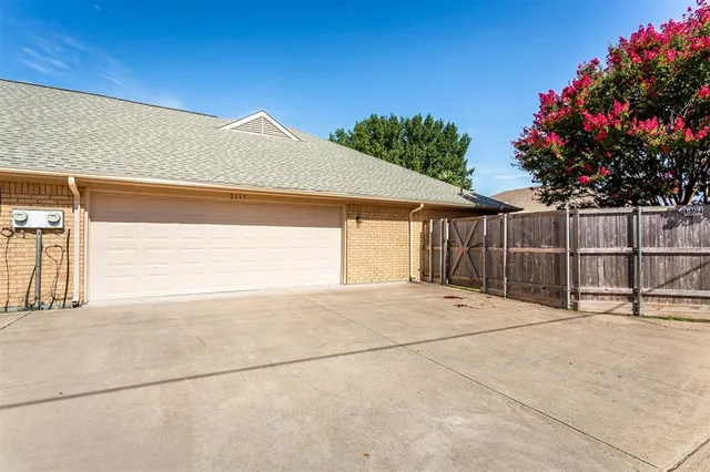a view of backyard with small cabin and wooden fence