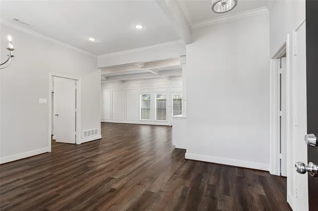 an empty room with wooden floor & windows