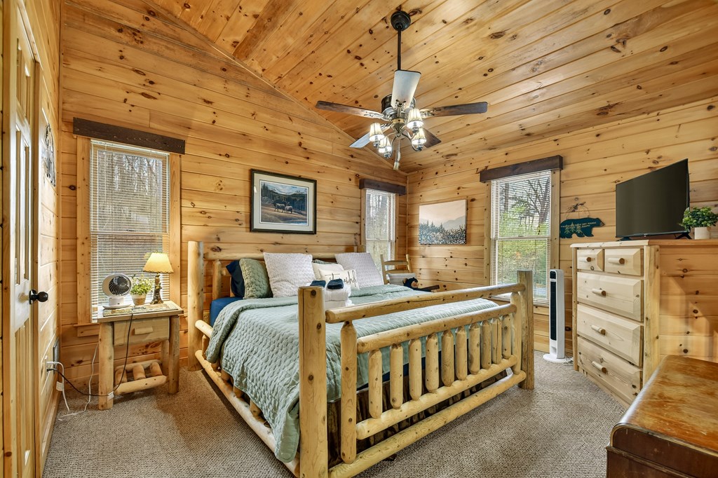 111 Roaring Creek Road Epworth, GA 30541 - Photo 14 of 63 a bedroom with a bed a chandelier and dresser