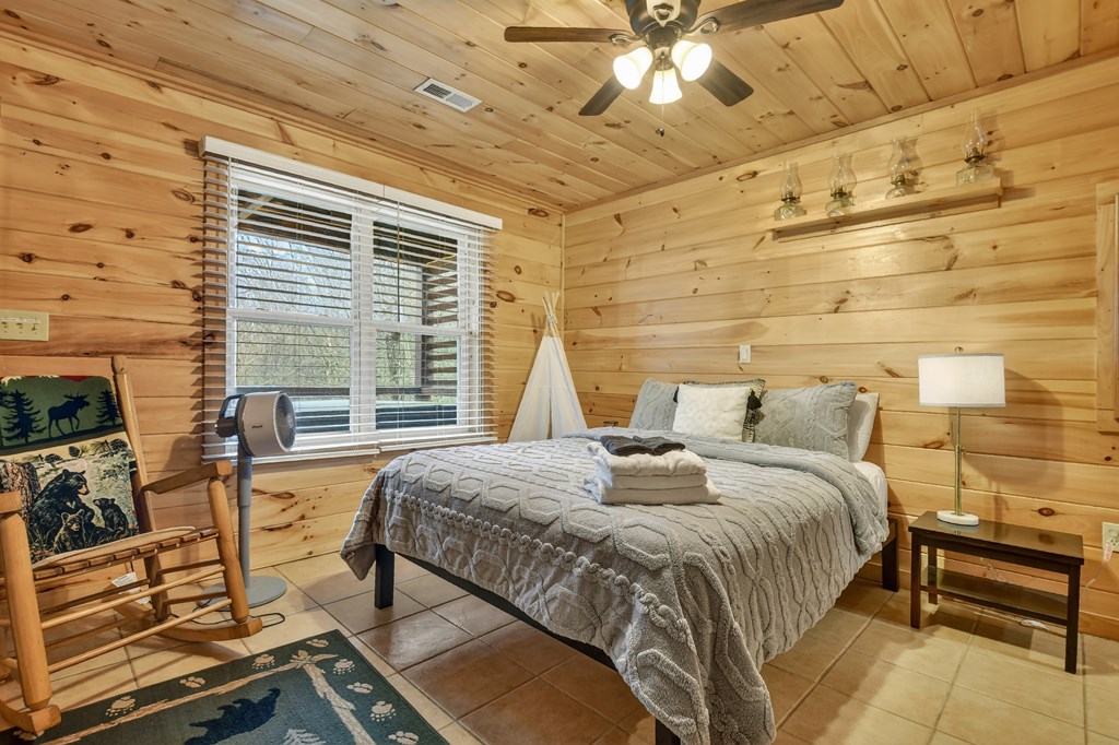 111 Roaring Creek Road Epworth, GA 30541 - Photo 22 of 63 a bedroom with a bed and a chandelier