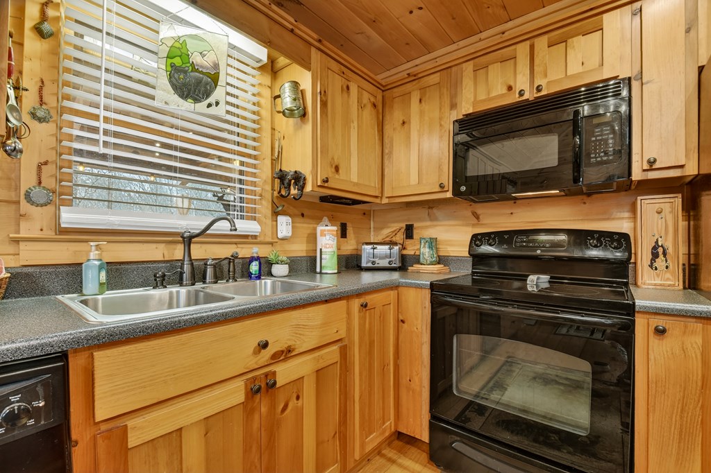 111 Roaring Creek Road Epworth, GA 30541 - Photo 24 of 63 a kitchen with granite countertop a sink a stove and microwave