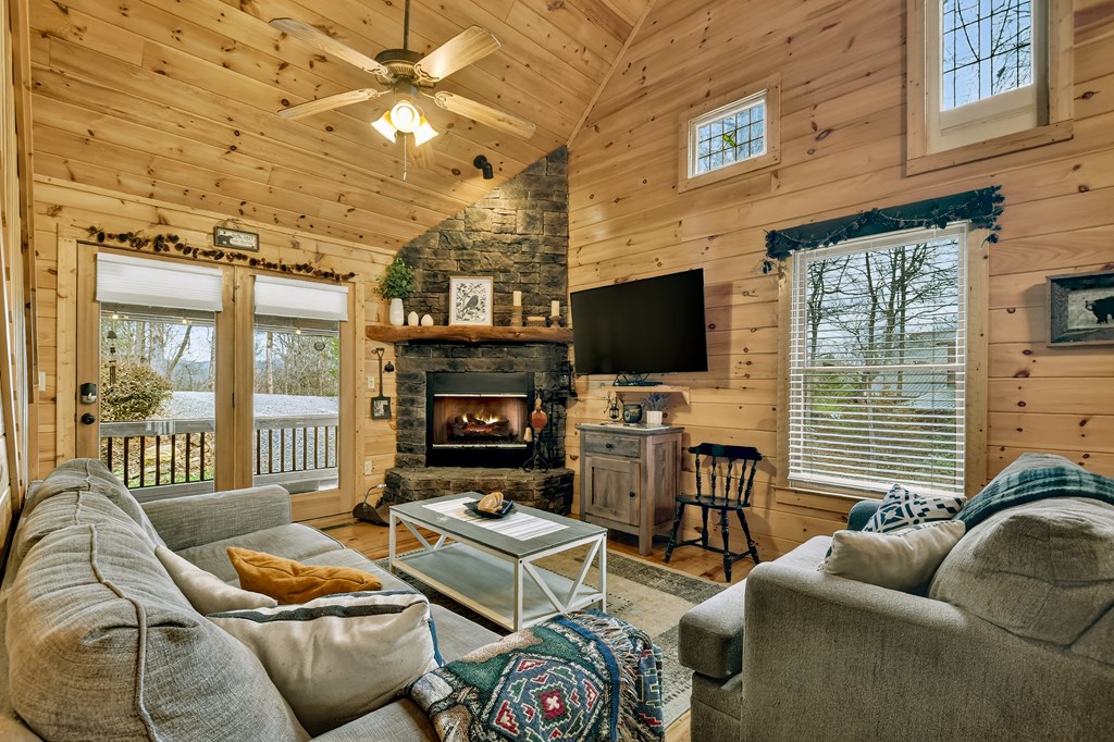 111 Roaring Creek Road Epworth, GA 30541 - Photo 37 of 63 a living room with furniture a fireplace and a flat screen tv