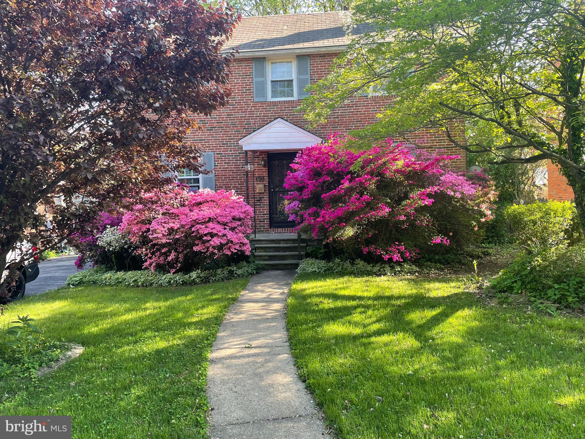 a view of a house with a big yard and large trees