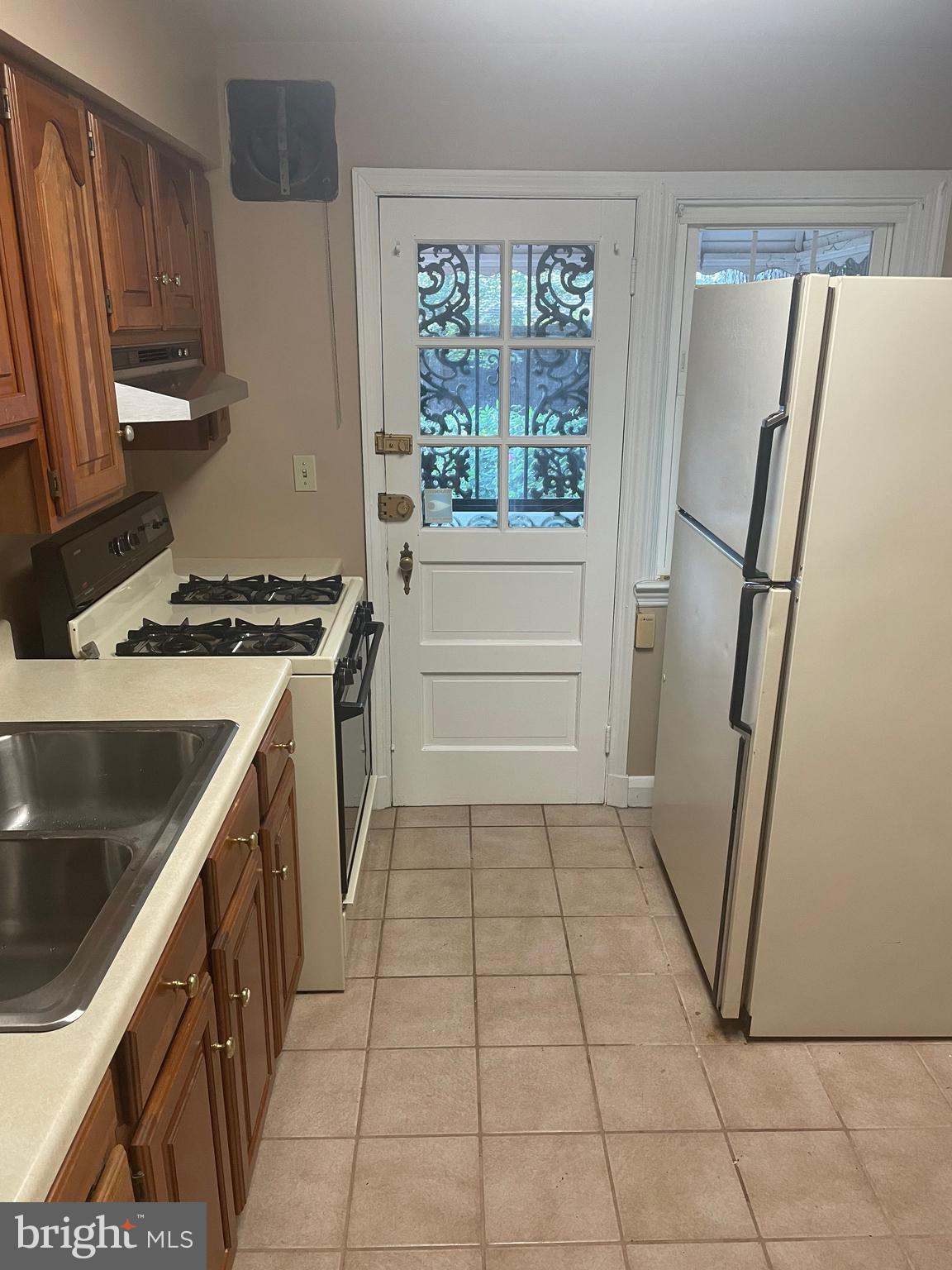 615 Overbrook Road Baltimore, MD 21212 - Photo 11 of 48 a kitchen with a sink a refrigerator and a stove