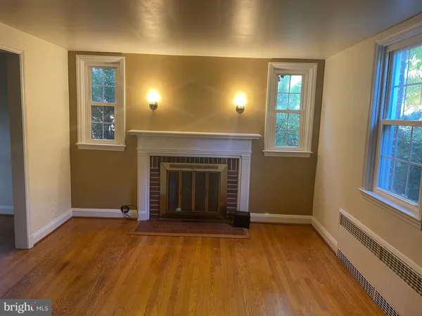 an empty room with windows and fireplace