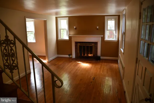 a view of an entryway with wooden floor and a fireplace
