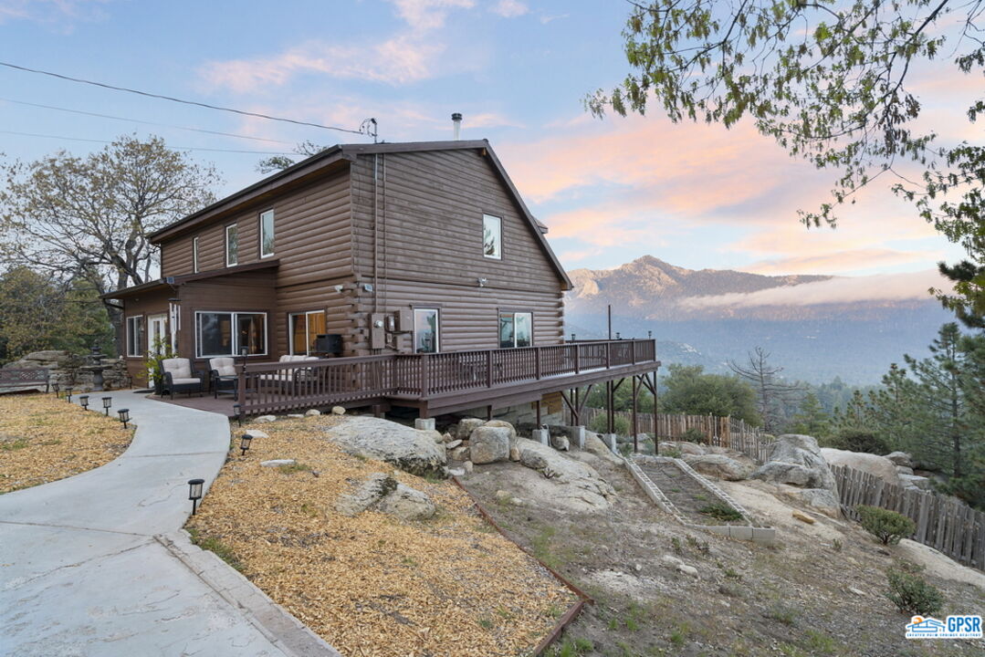 a view of house with yard and sitting area