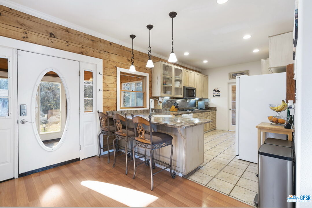53305 Big Rock Drive Idyllwild, CA 92549 - Photo 20 of 67 a kitchen with stainless steel appliances granite countertop a refrigerator a oven a sink and a dining table with wooden floor