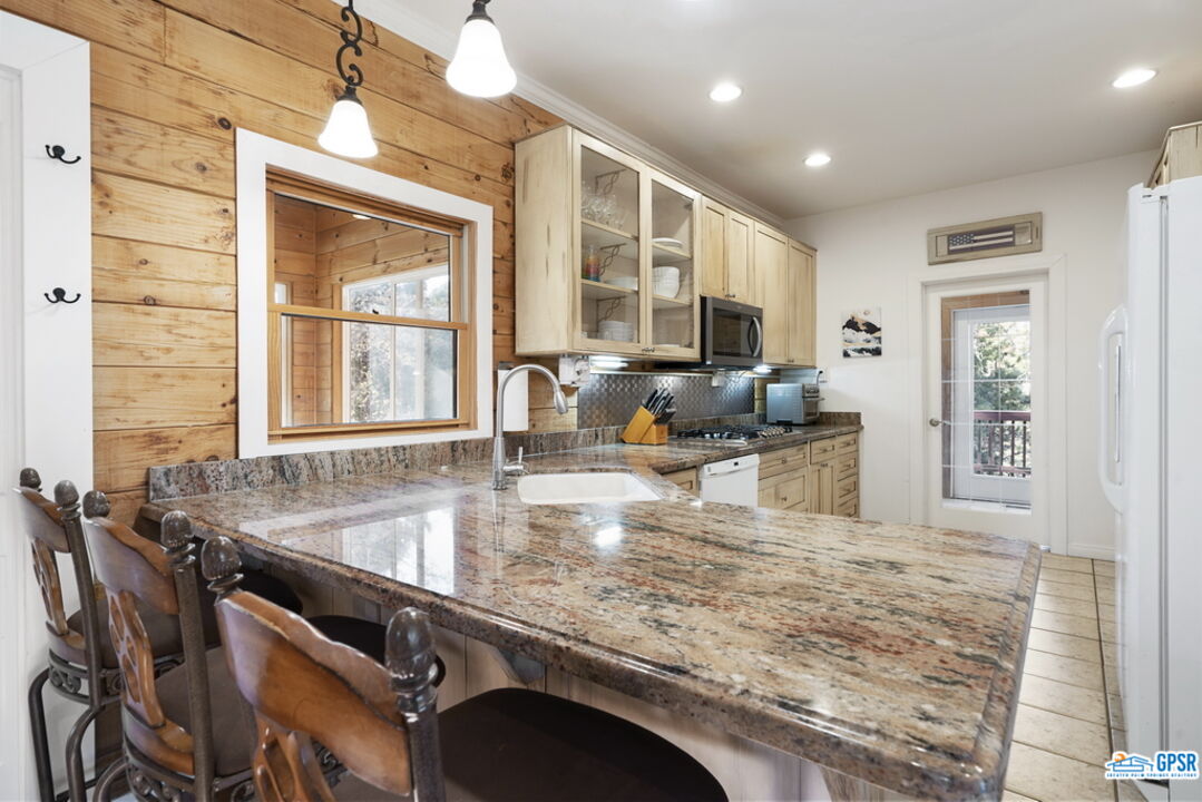 53305 Big Rock Drive Idyllwild, CA 92549 - Photo 21 of 67 a kitchen with kitchen island granite countertop a sink stove and cabinets