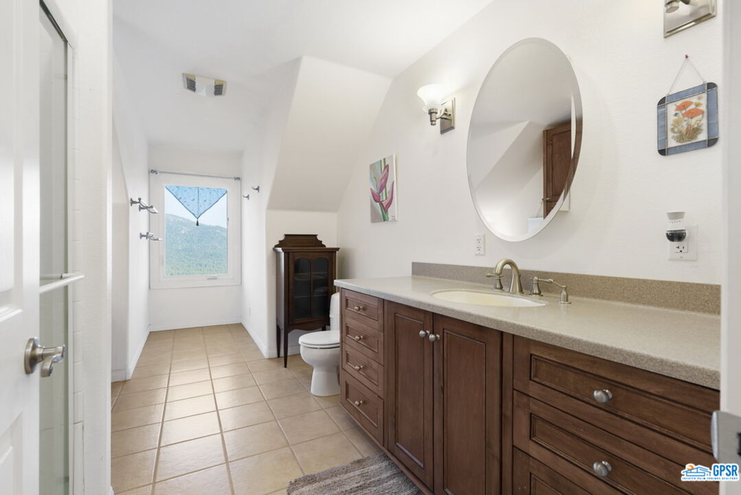 53305 Big Rock Drive Idyllwild, CA 92549 - Photo 44 of 67 a spacious bathroom with a granite countertop sink a mirror and a toilet