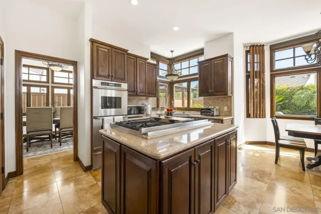 a kitchen with kitchen island granite countertop a stove top oven a sink and a refrigerator