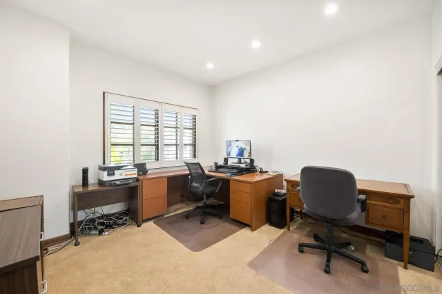 a view of a workspace with furniture and a window