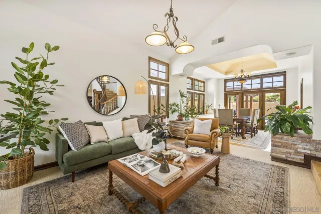 a living room with patio a couch and a chandelier