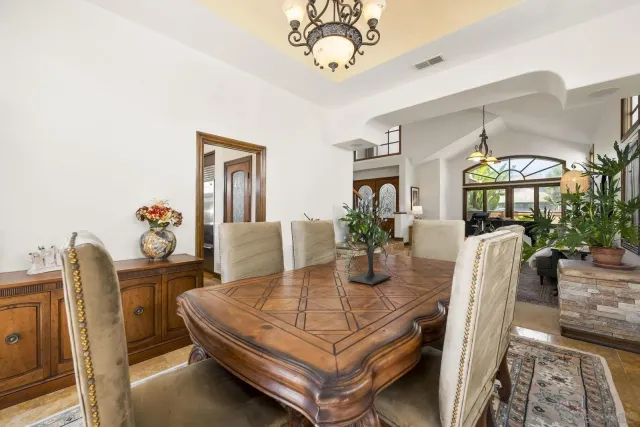a dining room with furniture potted plants and wooden floor