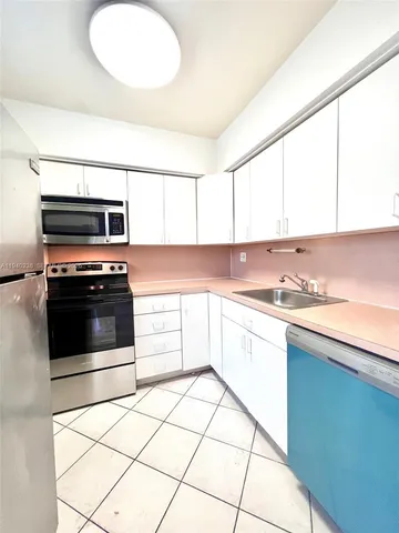 a kitchen with stainless steel appliances a stove a sink and a microwave