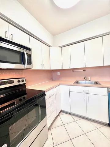 a kitchen with granite countertop a sink and cabinets