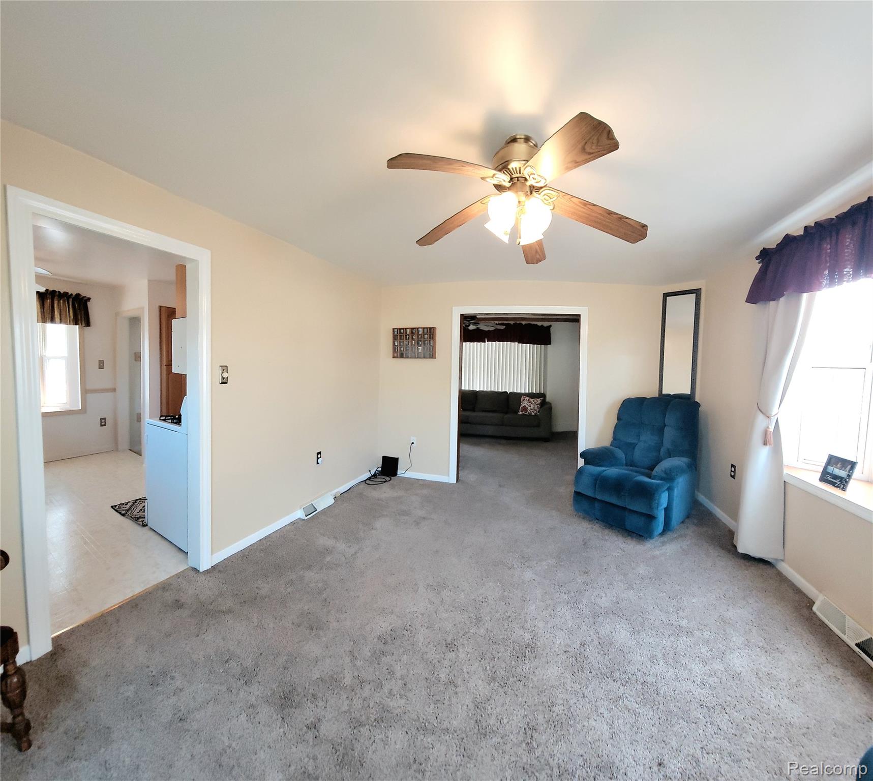 11227 Rivard Avenue Warren, MI 48089 - Photo 18 of 44 Carpeted living area featuring a ceiling fan with light fixture, neutral wall paint, and white trim