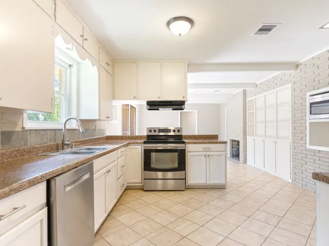 a kitchen with stainless steel appliances granite countertop a stove and a sink